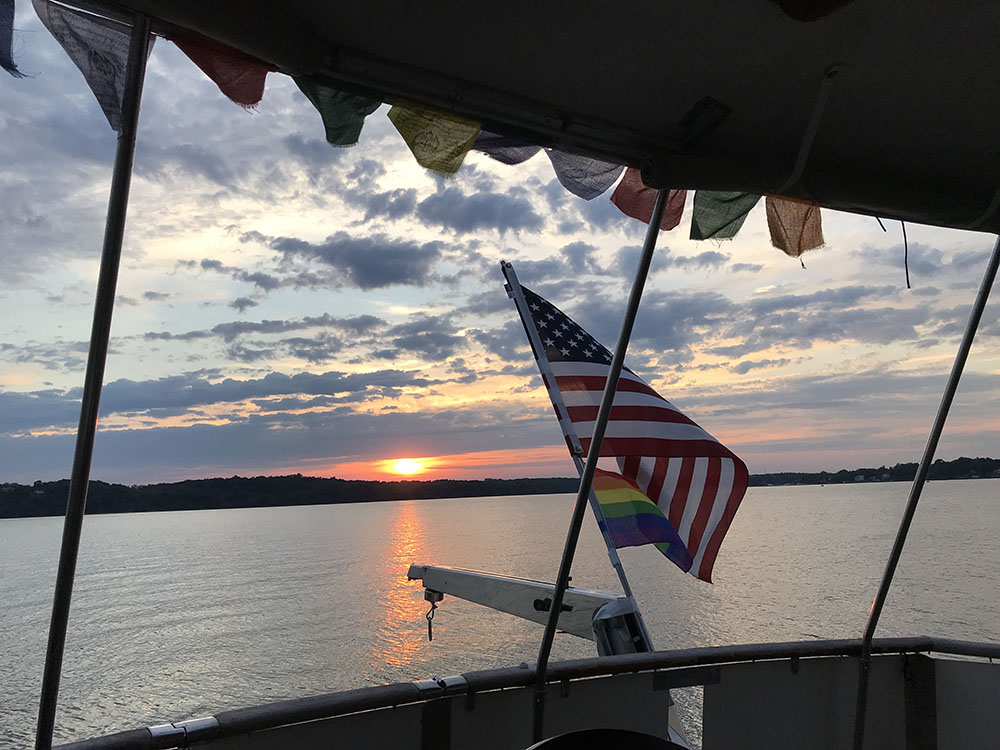 Sunset off the Back of a Boat, Framed by Flags.